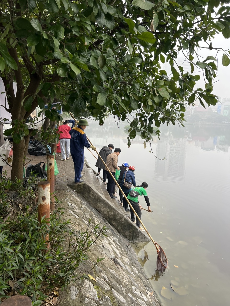 Công nhân thoát nước Hà Nội hướng dẫn giúp đỡ người dân thả cá không gây ô nhiễm môi trường