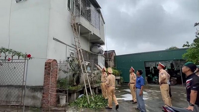 CSGT Công an huyện Thanh Miện sử dụng thang tre giải cứu 4 mẹ con chị Hiền bị mắc kẹt trong đám cháy trên tầng 2.