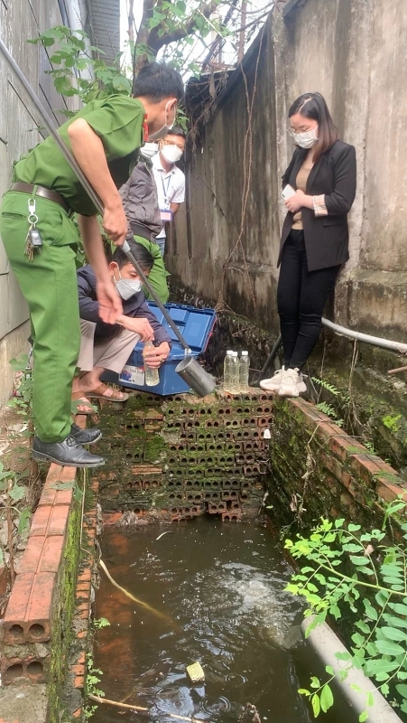 Lực lượng chức năng tiến hành lấy mẫu nước thải của công ty. Ảnh: Công an Hải Dương.