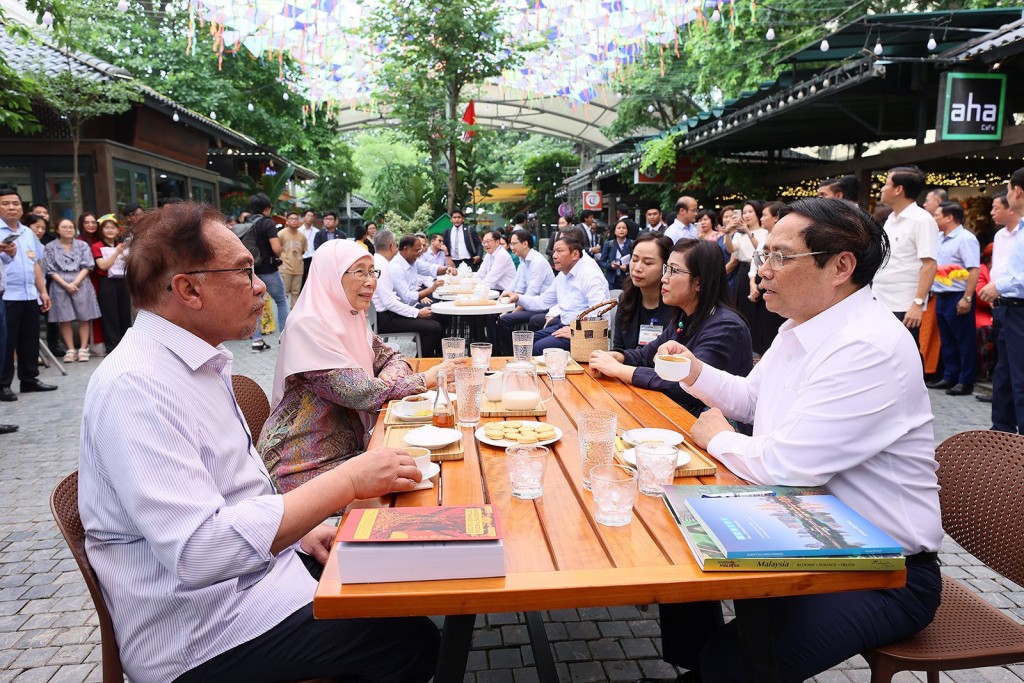 Thủ tướng Phạm Minh Chính và phu nhân cùng Thủ tướng Malaysia Anwar Ibrahim và phu nhân thưởng thức cà phê tại Phố sách Hà Nội. Ảnh: Dương Giang/TTXVN