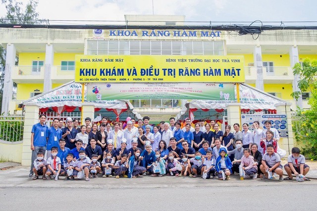 Em Benjamin Lý (áo xanh, đứng giữa) cùng đội ngũ y, bác sĩ và các em nhỏ tỉnh Trà Vinh được khám và điều trị
