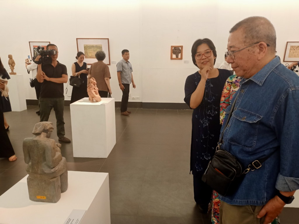 Nhà điêu khắc Vương Học Báo (áo xanh, phải ảnh) lặng ngắm tác phẩm “Chữ A đầu tiên” sau hơn 40 năm được bảo tàng Mỹ thuật Việt Nam lưu giữ.
