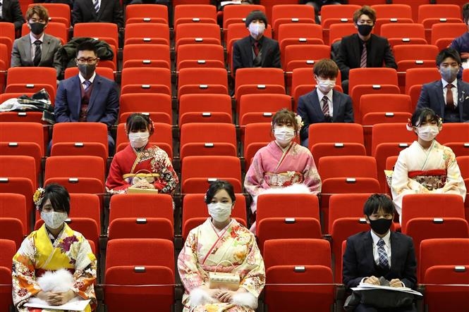 Các thanh niên Nhật Bản đeo khẩu trang và thực hiện giãn cách xã hội nhằm phòng dịch COVID-19 tại buổi lễ trưởng thành truyền thống ở Namie, tỉnh Fukushima ngày 9/1/2021 (Ảnh: Kyodo/TTXVN)