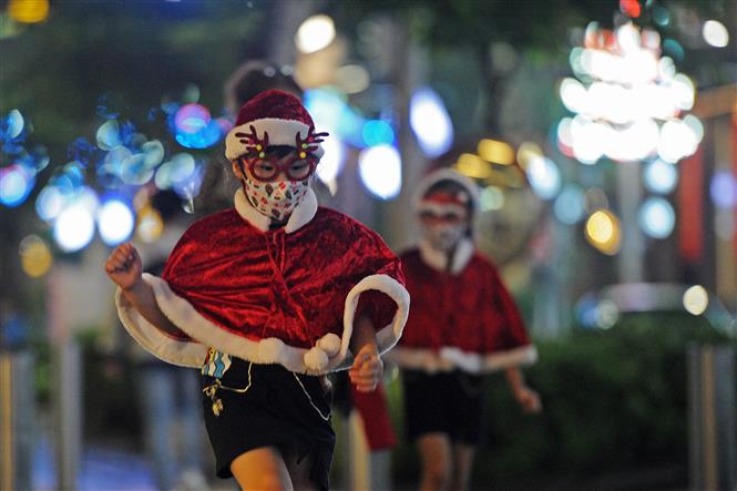 Trẻ em đeo khẩu trang hóa trang ông già Noel tại Singapore, ngày 16/12/2020 (Ảnh: THX/ TTXVN)