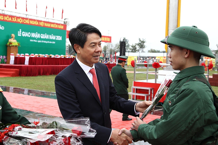 Phó Chủ tịch HĐND tỉnh Phạm Quang Nguyên và các đại biểu tặng hoa chúc mừng tân binh trước giờ lên đường nhập ngũ