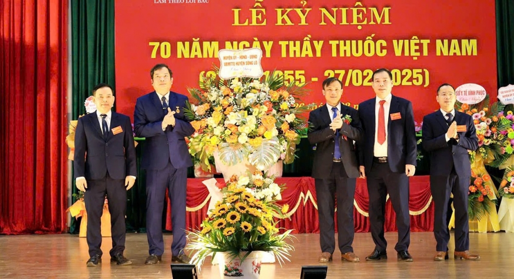 Đại diện lãnh đạo UBND huyện Sông Lô tặng hoa chúc mừng Trung tâm Y tế huyện Sông Lô.