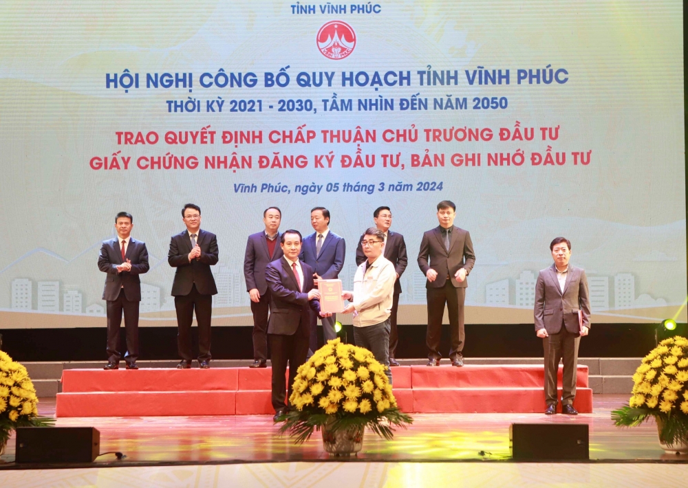 Phó Bí thư thường trực Tỉnh ủy Vĩnh Phúc Phạm Hoàng Anh (trái) trao giấy chứng nhận đăng ký đầu tư cho một số dự án đầu tư trực tiếp trên địa bàn tỉnh Vĩnh Phúc.