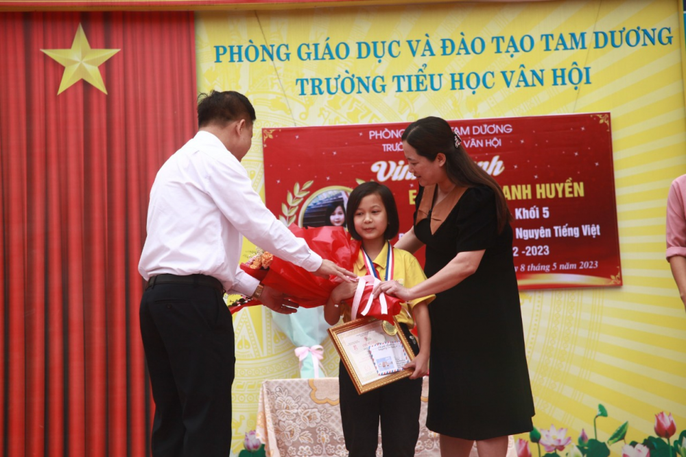 Nhà giáo Nguyễn Thị Tình và em Phan Thanh Huyền nhận hoa, huy chương và chứng nhận đạt giải Ba kì thi Đình cấp Quốc gia Trạng nguyên Tiếng Việt