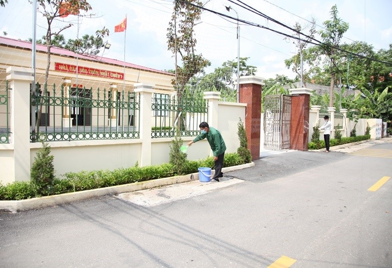 Người dân thôn Nhật Chiêu 1, xã Liên Châu, huyện Yên Lạc chăm sóc cây xanh tại nhà văn hóa thôn. Ảnh: Dương Chung