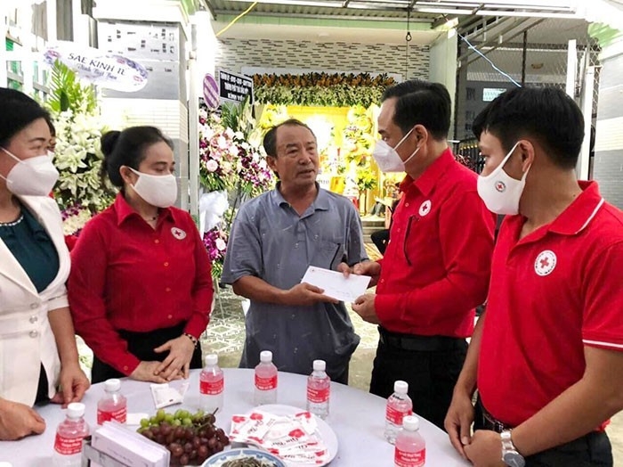 Ông Vũ Thanh Lưu, Phó Chủ tịch Hội Chữ thập đỏ Việt Nam thăm hỏi, động viên và trao hỗ trợ tiền mặt cho gia đình có người tử vong trong vụ hỏa hoạn