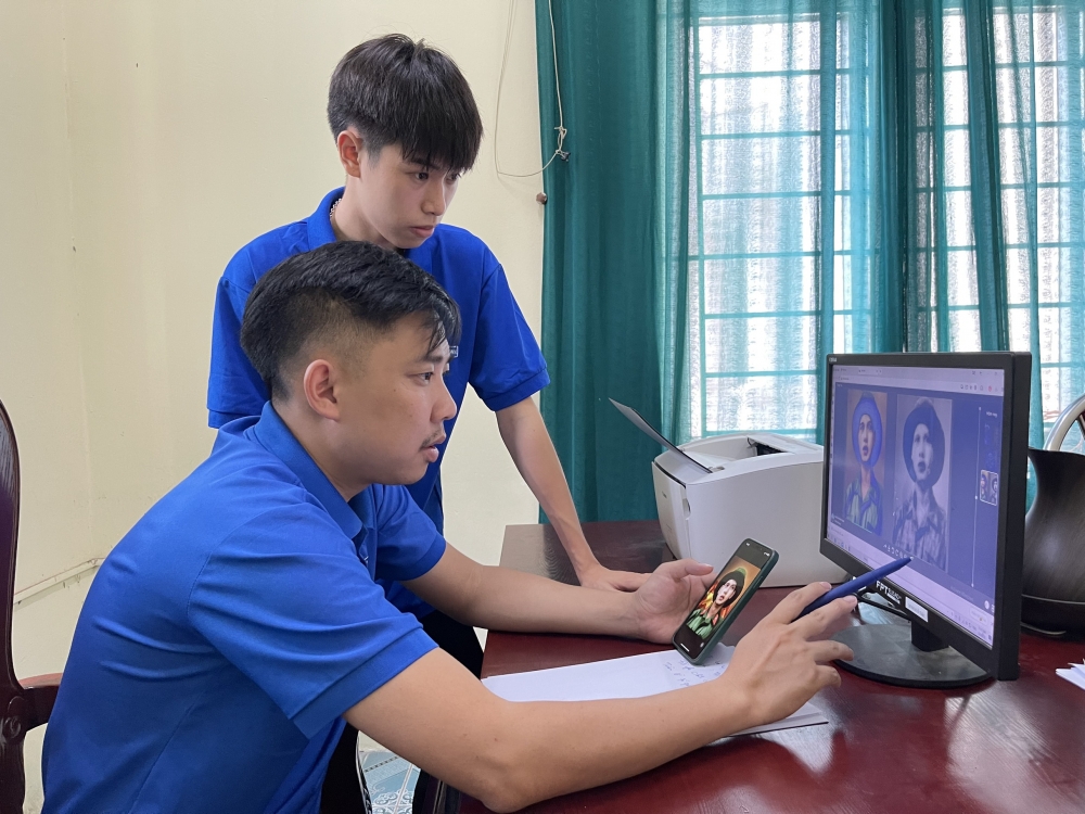 Bí thư Đoàn Thanh niên thị trấn Tam Sơn Nguyễn Ngọc Khánh (người ngồi) trao đổi với đoàn viên về các thông tin liên quan đến việc phục dựng chân dung liệt sĩ. 
