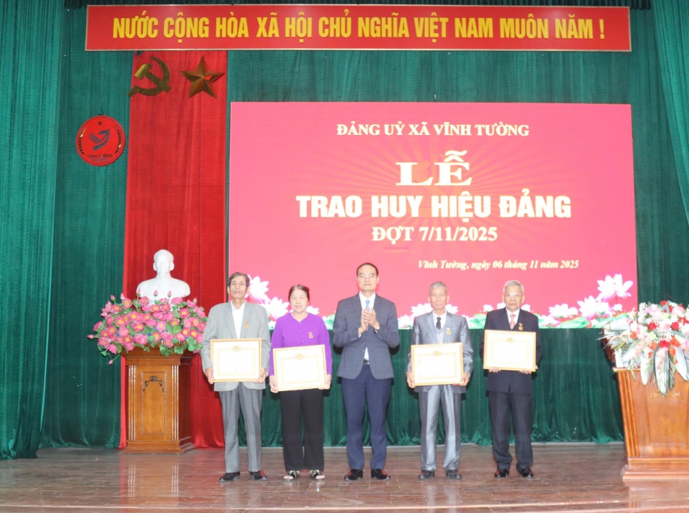đồng chí Nguyễn Đình Bảng – Phó Bí thư Thường trực Đảng ủy xã Vĩnh Tường trao huy hiệu Đảng tặng các đồng chí đảng viên