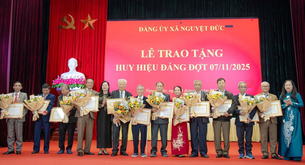 Phó Trưởng Ban Thường trực Ban Tổ chức Tỉnh ủy Phạm Thị Hồng Nhung và Bí thư Đảng ủy, Chủ tịch HĐND xã Nguyệt Đức Nguyễn Thị Huấn trao Huy hiệu Đảng cho các đảng viên