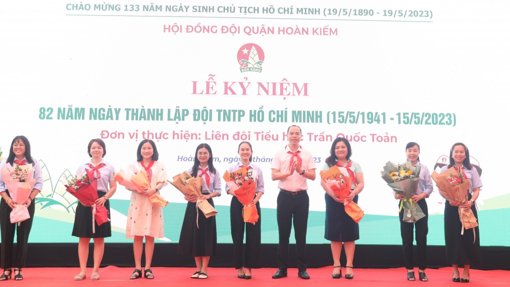 Phó Bí thư Thành đoàn Hà Nội Nguyễn Tiến Hưng tặng hoa chúc mừng giáo viên làm Tổng phụ trách Đội