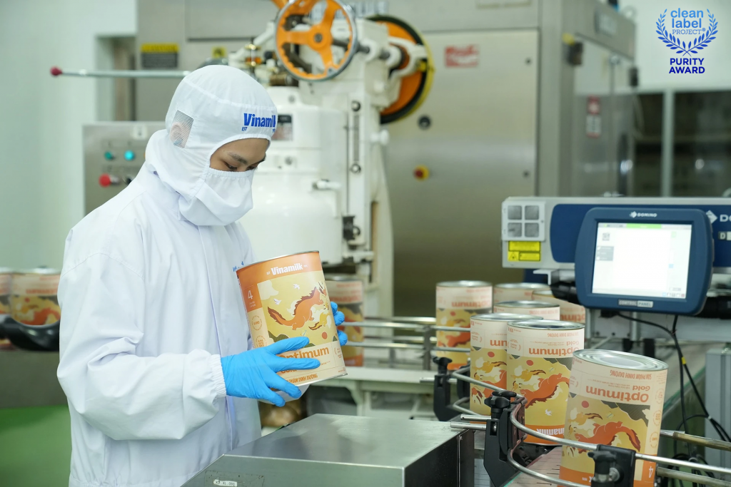 Nhân viên nhà máy kiểm tra chất lượng hộp sữa được đóng gói bằng dây chuyền tự động