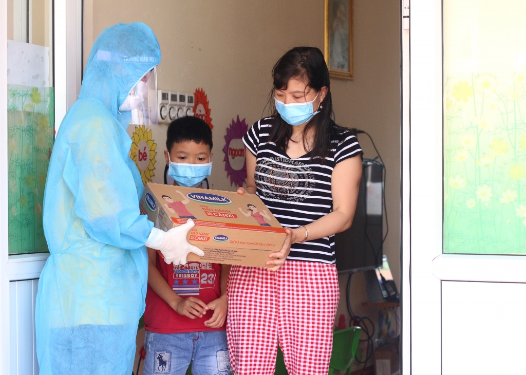 Hình 5: Người dân, trẻ em trong nơi cách ly tập trung tại huyện Thuận Thành, một trong những điểm nóng về dịch ở Bắc Ninh, đón nhận món quà từ Vinamilk