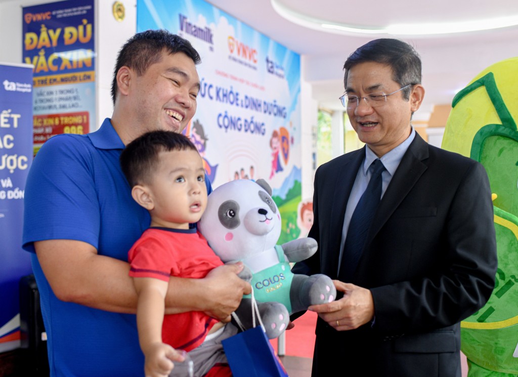 Ông Nguyễn Quang Trí – Giám đốc Điều hành Vinamilk, tặng quà cho các gia đình, các bé đến tiêm ngừa tại Trung tâm VNVC trong ngày kí kết hợp tác. Ảnh: Vi Nam