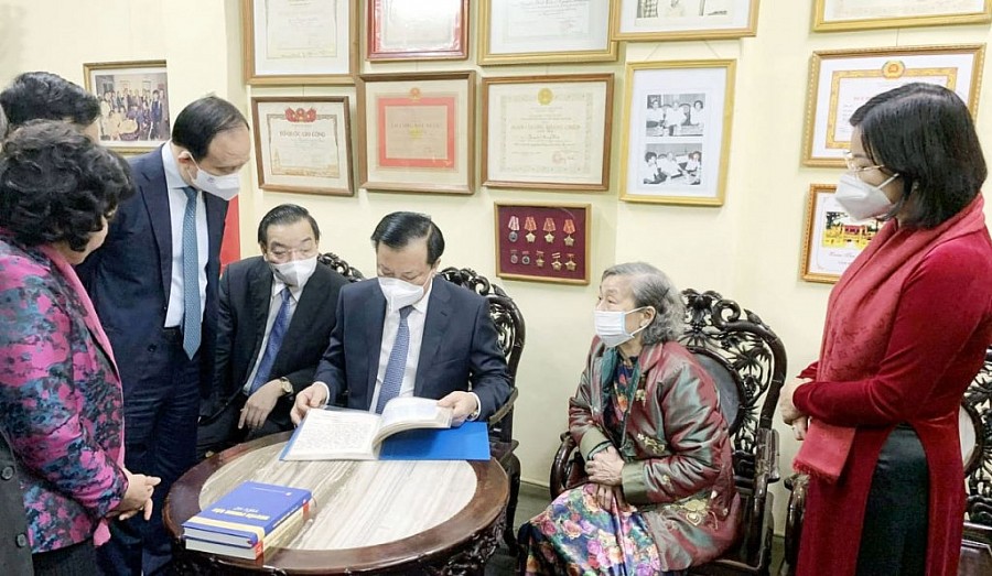 Bí thư Thành ủy Hà Nội Đinh Tiến Dũng và các đồng chí lãnh đạo TP xem cuốn sổ truyền thống của gia đình đồng chí Nguyễn Phong Sắc
