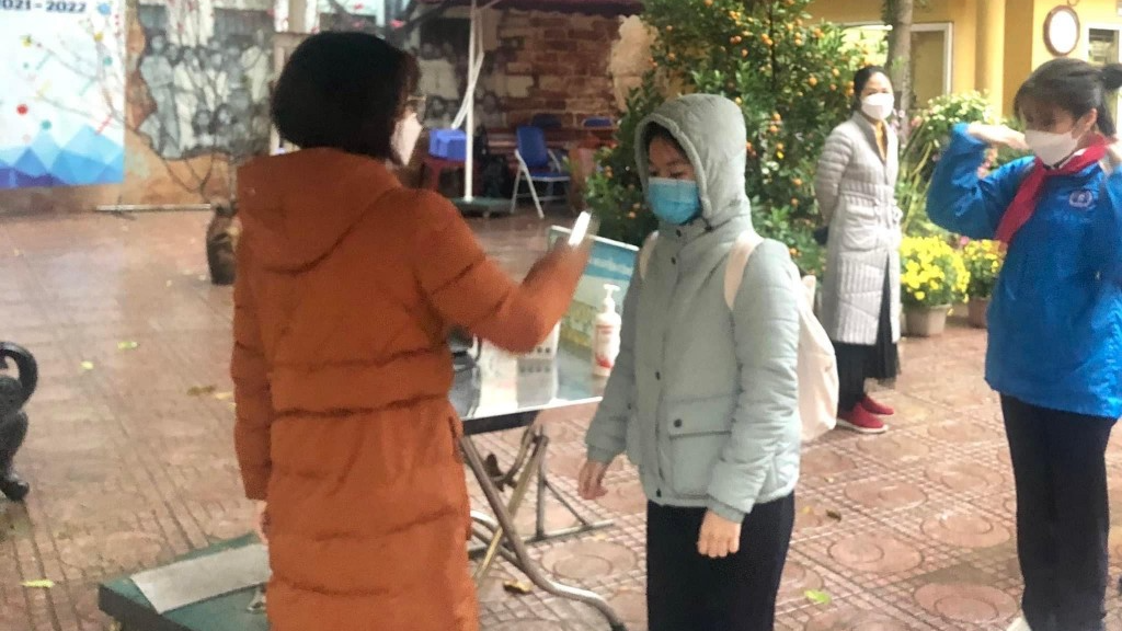 Lực lượng Đoàn Thanh niên trường THCS Nguyễn Công Trứ hỗ trợ đo thân nhiệt cho học sinh tại cổng trường