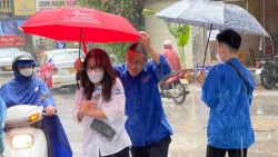 Tình nguyện viên Thủ đô “đầu trần” hứng mưa, nhường  ô cho các thí sinh