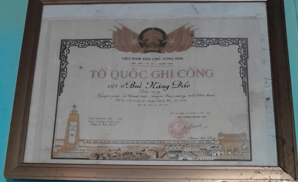 Tấm bằng Tổ quốc ghi công của liệt sĩ Bùi Năng Đắc được treo trang trọng tại quê nhà. (Ảnh: Gia đình cung cấp) Những cuộc hội ngộ đặc biệt bên bến phà II Long Đại