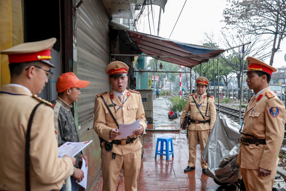 Phát tờ rơi tuyên truyền cho người dân sinh sống dọc tuyến đường. Ảnh: Chu Dũng