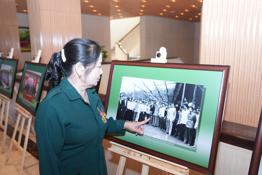 Cô Nguyễn Thị Thanh Hà xem lại những bức ảnh chụp đoàn thanh niên tiền trạm Thủ đô đi xây dựng kinh tế mới tại Lâm Đồng
