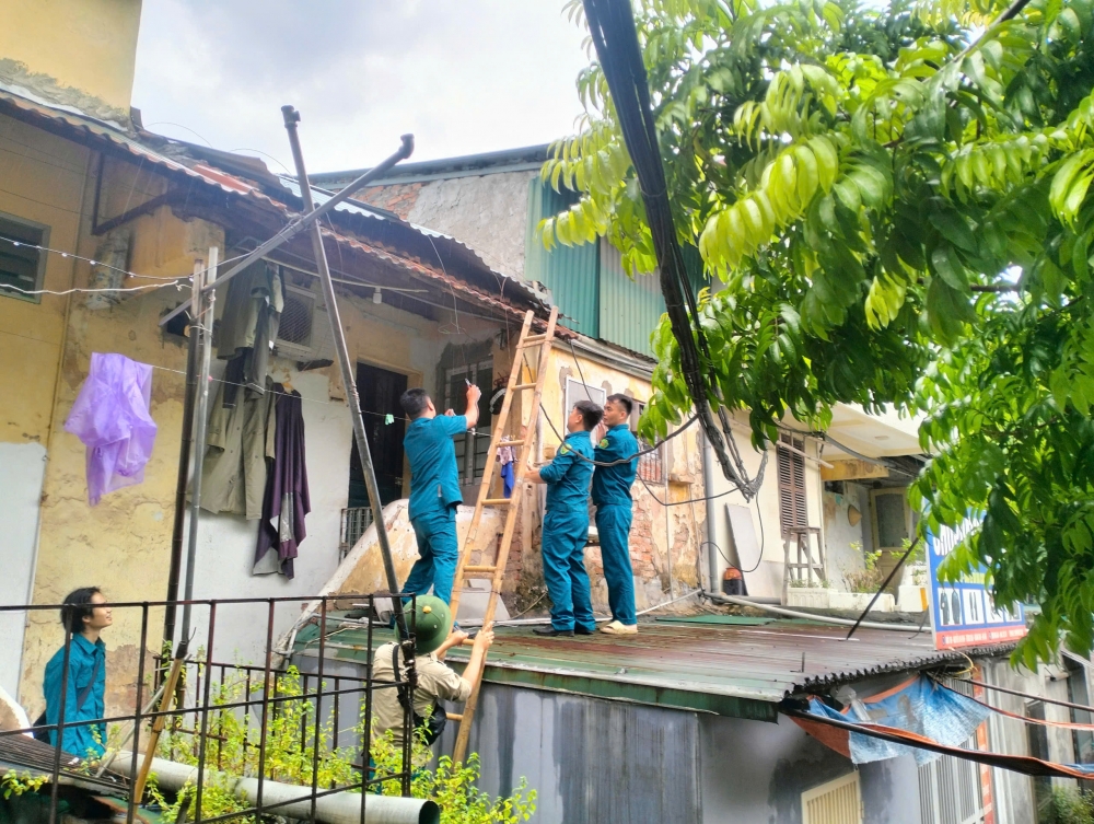 Lực lượng chức năng gia cố mái nhà giúp người dân
