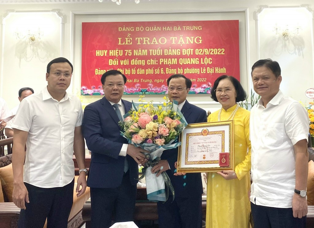 Bí thư Thành ủy Đinh Tiến Dũng trao Huy hiệu Đảng cho hai đảng viên lão thành