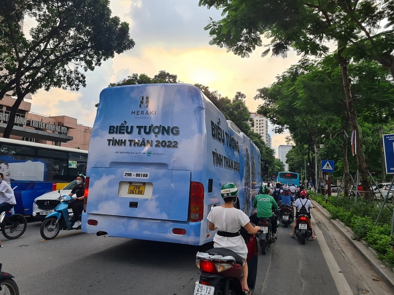 Chiếc xe kín đề can quảng cáo nối đuôi nhau trên phố Huỳnh Thúc Kháng