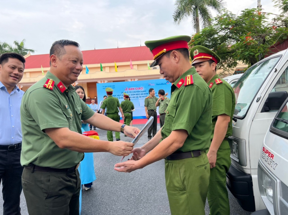 Đại tá Phạm Thanh Hùng trao giấy tờ xe cho công an xã