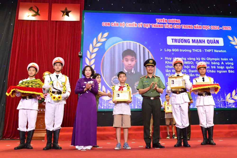 Đại tá Nguyễn Ngọc Quyền, Phó Giám đốc Công an TP Hà Nội và bà Lê Kim Anh, Chủ tịch Hội Liên hiệp Phụ nữ TP Hà Nội tặng quà cho các cháu học sinh đạt thành tích xuất sắc. (Ảnh: Trọng Phú)