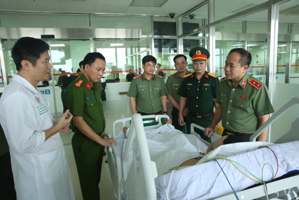 Giám đốc Công an Hà Nội và các thành viên trong đoàn thăm hỏi, trao đổi tình hình sức khoẻ của Đại uý Long