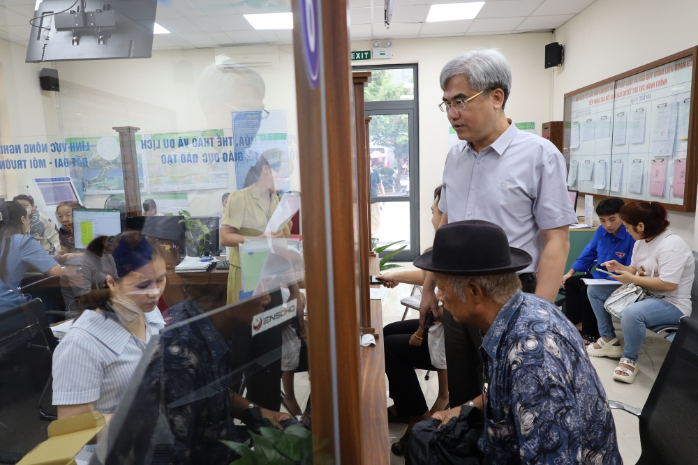 Ông Quốc - Phó Chủ tịch UBND phường hỏi han và xin ý kiến đóng góp của người dân cao tuổi khi thực hiện dịch vụ tại Điểm tiếp nhận phục vụ hành chính công của phường