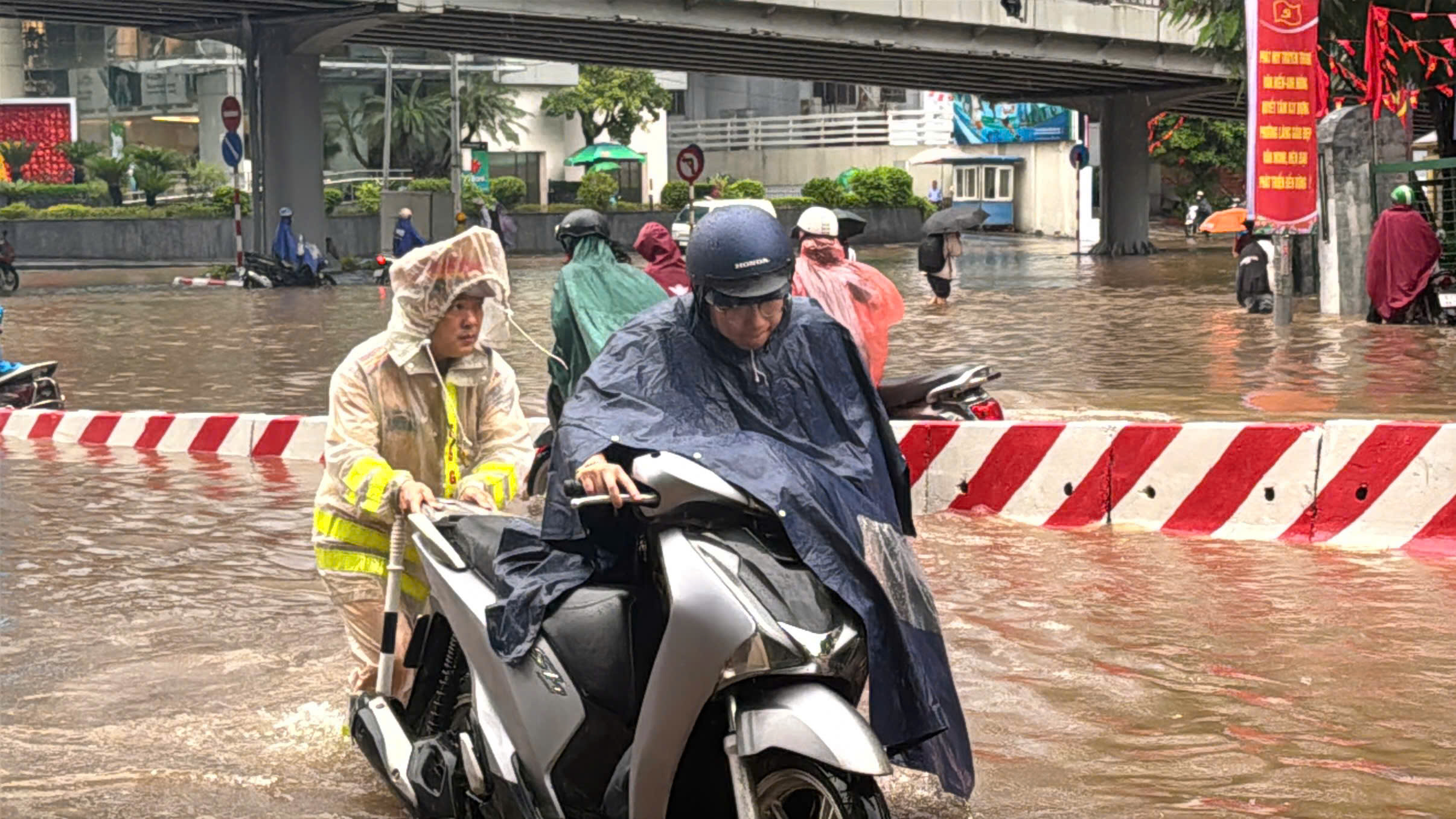 Cảnh sát giao thông Hà Nội căng mình phân luồng, giúp dân trong mưa ngập