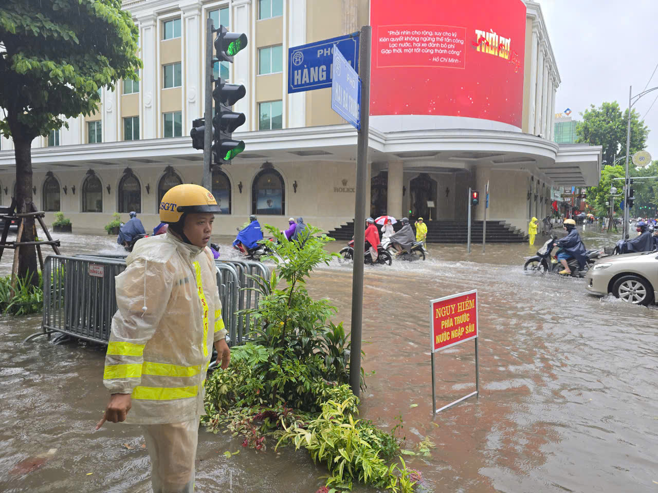 Cảnh sát giao thông Hà Nội căng mình phân luồng, giúp dân trong mưa ngập