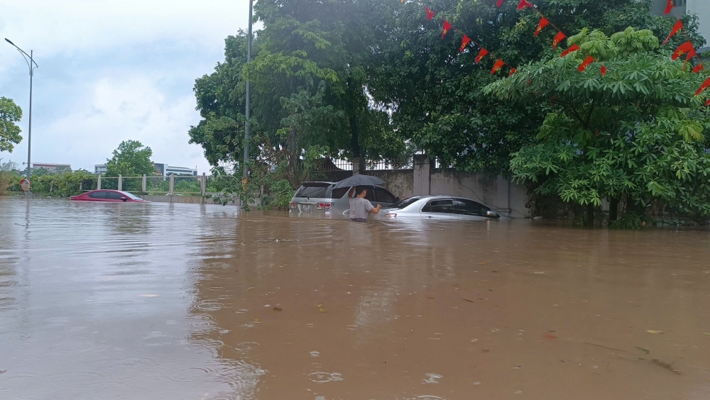 Cảnh sát giao thông Hà Nội căng mình phân luồng, giúp dân trong mưa ngập