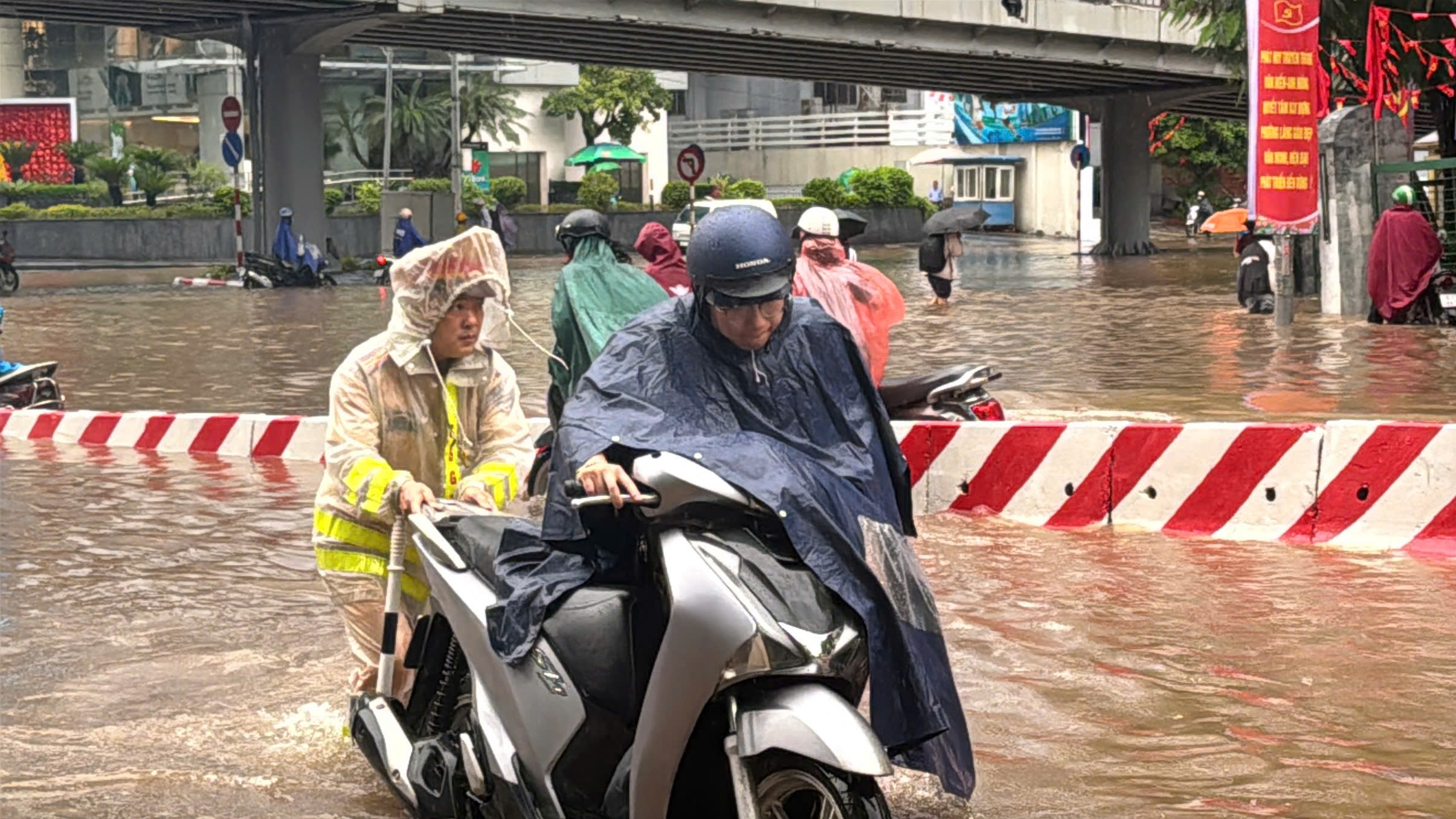 Cảnh sát giao thông Hà Nội căng mình phân luồng, giúp dân trong mưa ngập