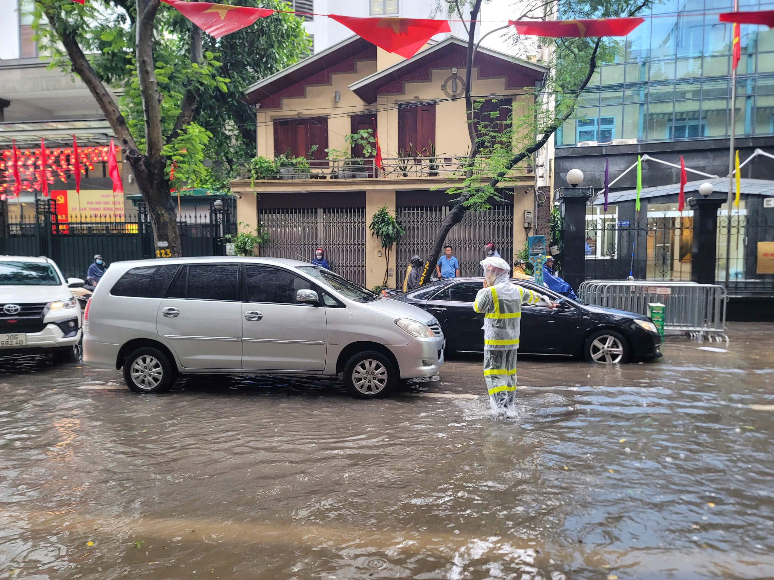 Cảnh sát giao thông Hà Nội căng mình phân luồng, giúp dân trong mưa ngập
