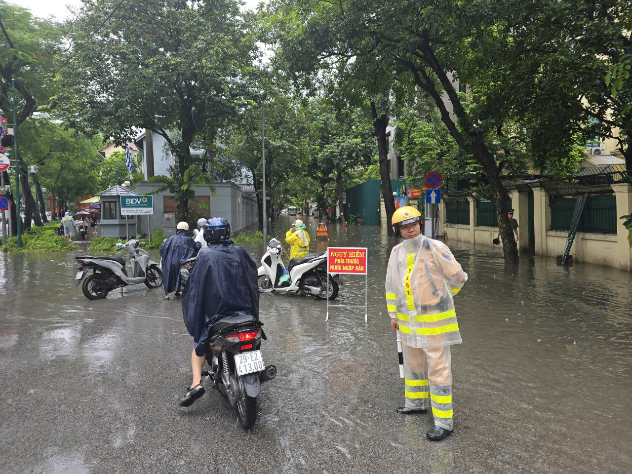 Cảnh sát giao thông Hà Nội căng mình phân luồng, giúp dân trong mưa ngập