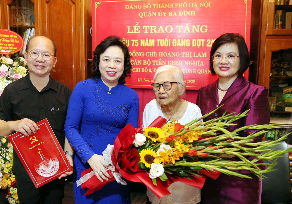Phó Bí thư Thường trực Thành ủy Ngô Thị Thanh Hằng trao tặng Huy hiệu 75 năm tuổi Đảng và tặng hoa chúc mừng đảng viên lão thành Hoàng Thị Lam