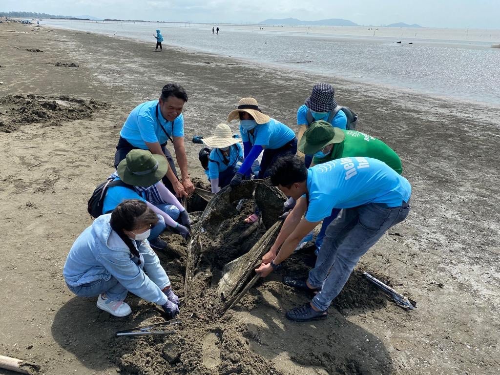 Cán bộ nhân viên Suntory PepsiCo Việt Nam và các tình nguyện viên cố gắng lấy rác bị vùi sâu dưới cát