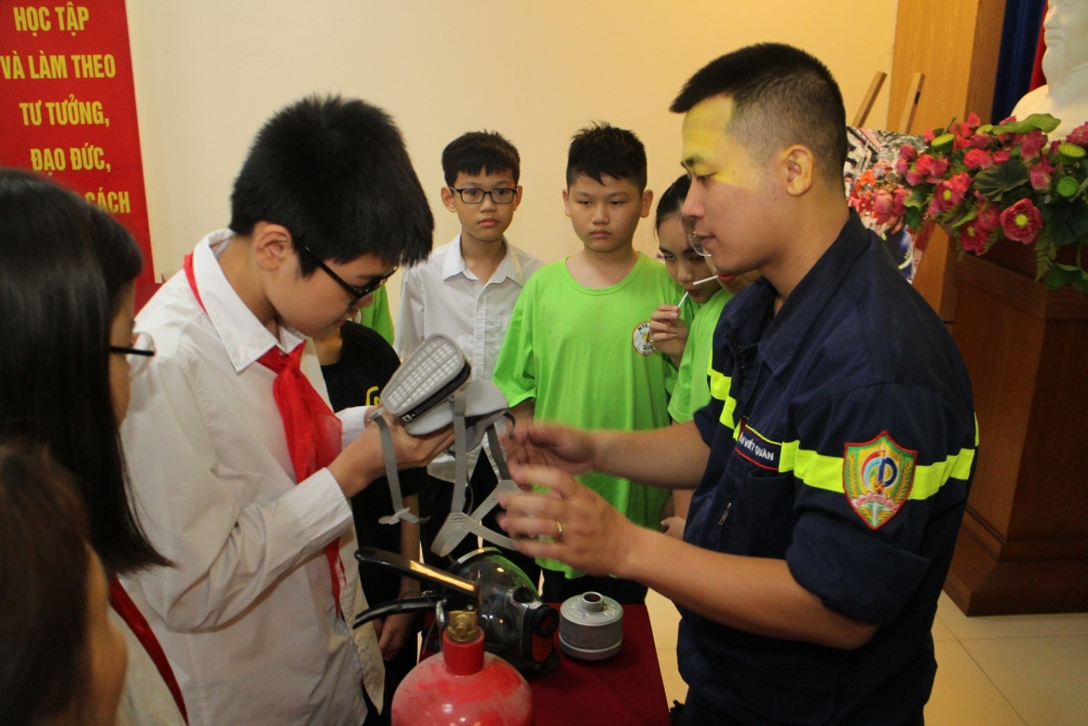 Công an quận Hoàn Kiếm hướng dẫn trẻ sử dụng mặt nạ chống độc trong lúc hỏa hoạn