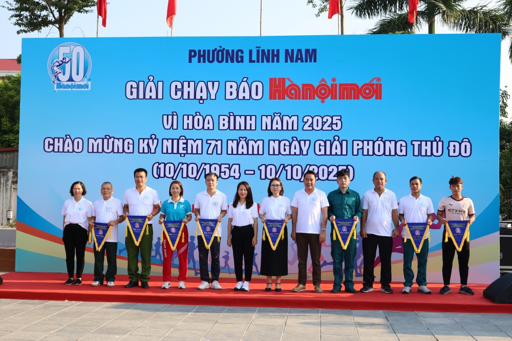 Đại diện Ban Tổ chức trao cờ lưu niệm cho các đội tham gia