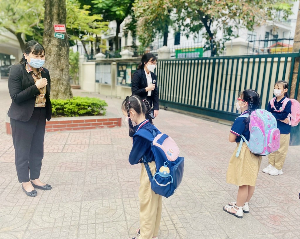 Học sinh trường Tiểu học Ái Mộ B chào giáo viên, nhân viên tại cổng trường