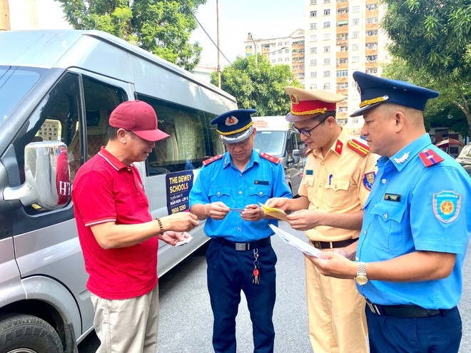 Lực lượng liên ngành quận Cầu Giấy kiểm tra các giấy tờ liên quan đến xe đưa đón học sinh