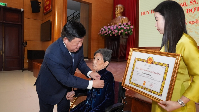 Nhiều đảng viên dù đi lại khó khăn, trong thời tiết không thuận lợi nhưng vẫn trực tiếp đến dự lễ trao tặng huy hiệu Đảng.