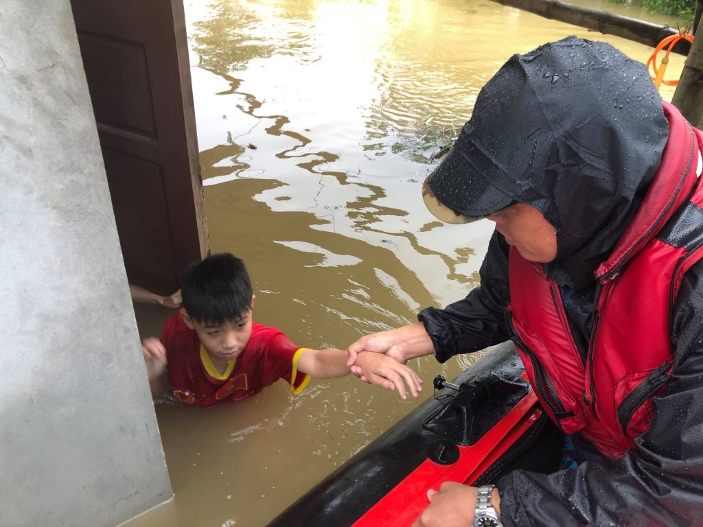 Thuyền hơi của anh Trọng đón một gia đình bị mắc kẹt bởi nước lũ tại huyện Quảng Ninh, tỉnh Quảng Bình