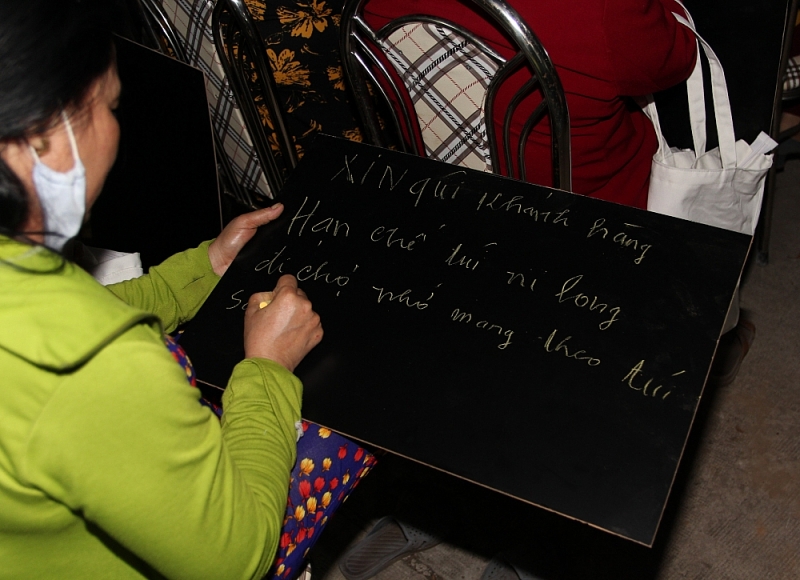 Tiểu thương viết lời kêu gọi hạn chế dùng túi ni lông tại sự kiện.