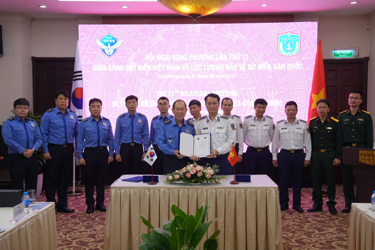 Cảnh sát biển Việt Nam và Lực lượng Bảo vệ bờ biển Hàn Quốc trao đổi biên bản ký kết tại hội nghị.